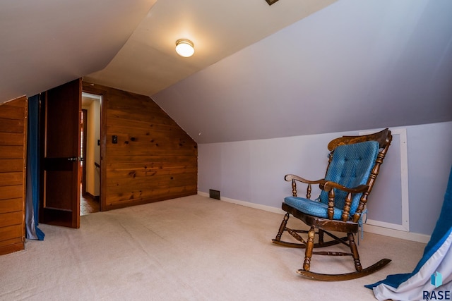 sitting room featuring carpet, lofted ceiling, and wooden walls