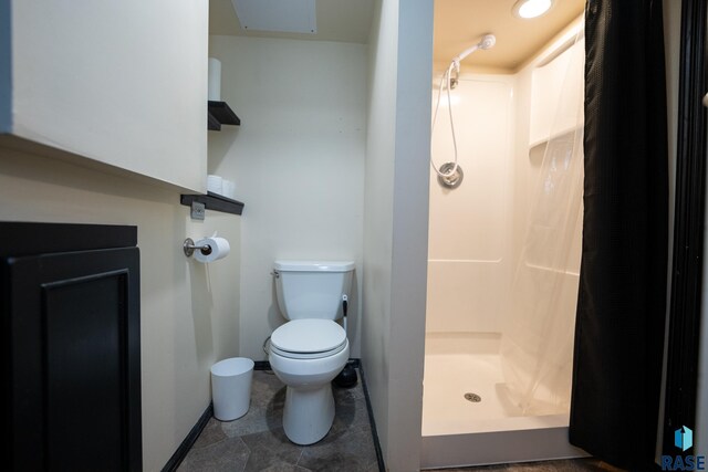 bathroom featuring a shower with shower curtain and toilet