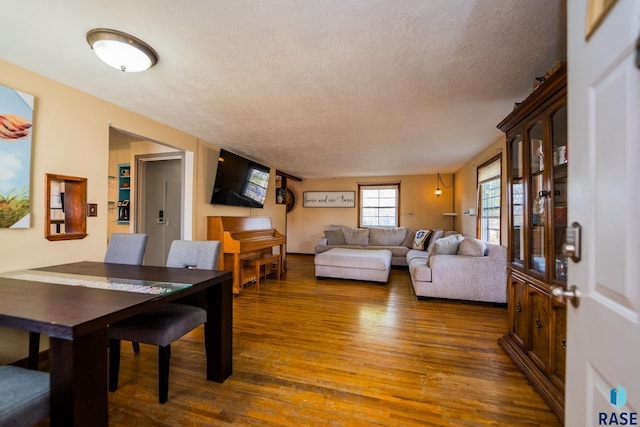 dining area with dark hardwood / wood-style flooring and a textured ceiling