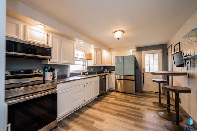 kitchen with white cabinets, appliances with stainless steel finishes, plenty of natural light, and sink