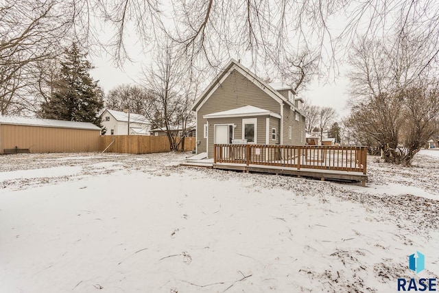 snow covered house with a wooden deck