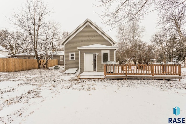 snow covered back of property featuring a wooden deck