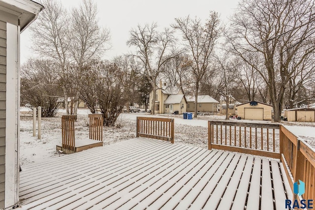 snow covered deck featuring an outbuilding