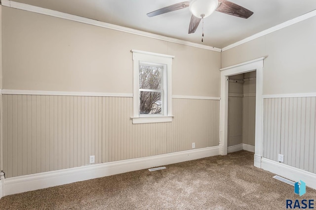 unfurnished bedroom with carpet, a closet, ceiling fan, and ornamental molding