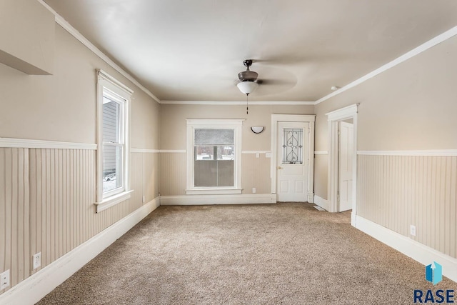 spare room with carpet flooring, ceiling fan, and crown molding