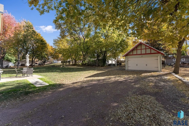 exterior space featuring a garage, an outdoor structure, and a front lawn