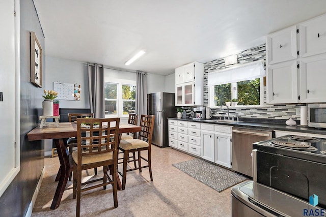 kitchen featuring white cabinets, decorative backsplash, stainless steel appliances, and sink