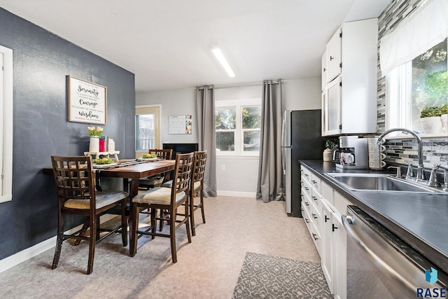 kitchen with tasteful backsplash, sink, white cabinets, and appliances with stainless steel finishes