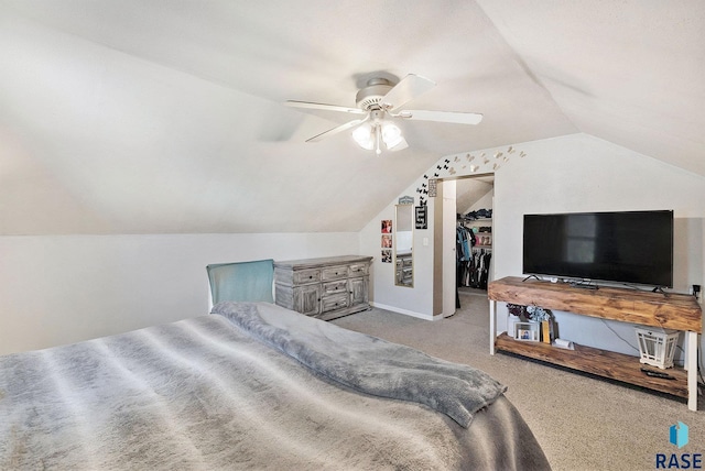 bedroom featuring lofted ceiling, light carpet, ceiling fan, a spacious closet, and a closet