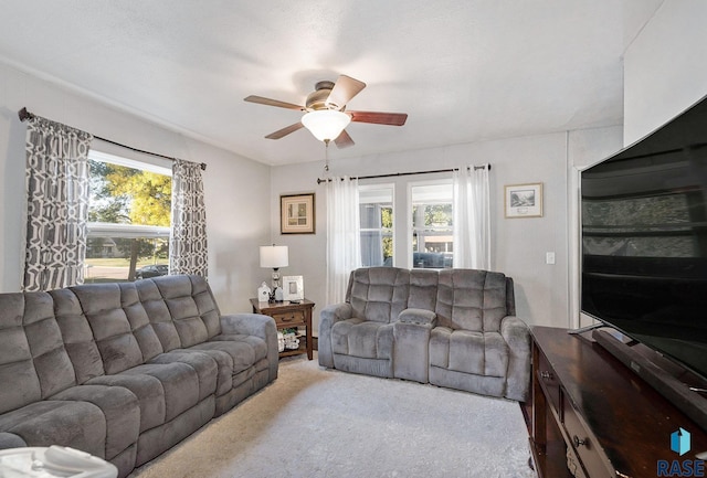 carpeted living room featuring ceiling fan, plenty of natural light, and a textured ceiling