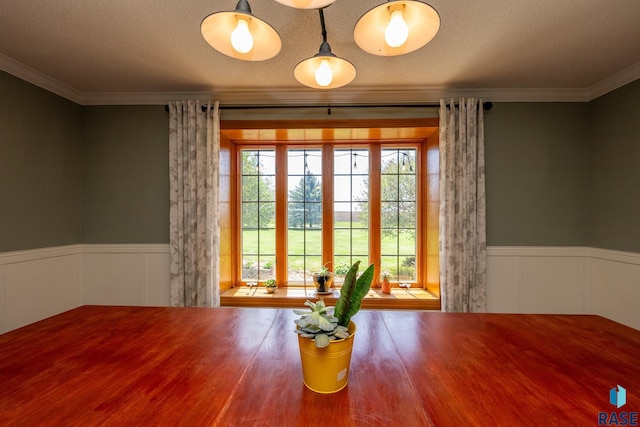 unfurnished dining area featuring crown molding, wood-type flooring, and a textured ceiling