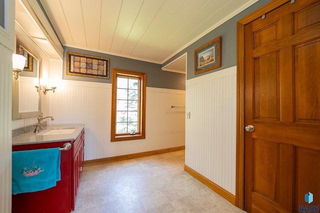 bathroom featuring vanity, wooden walls, and crown molding