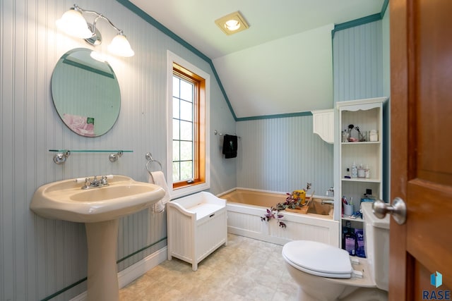 bathroom featuring a bathing tub, toilet, lofted ceiling, and sink