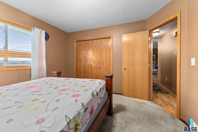 carpeted bedroom with a textured ceiling and a closet