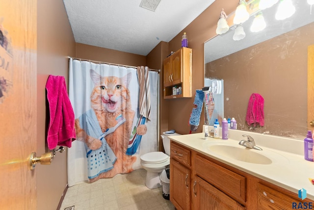 bathroom featuring a textured ceiling, vanity, toilet, and curtained shower