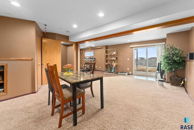 carpeted dining area featuring beamed ceiling