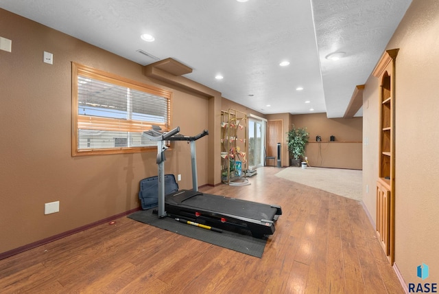 workout area with wood-type flooring and a textured ceiling