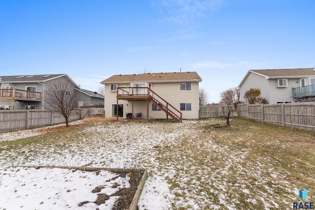 snow covered house with a wooden deck