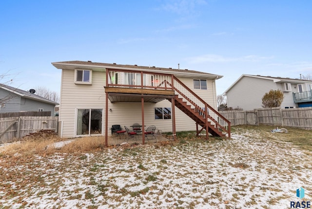 snow covered property featuring a patio area and a deck