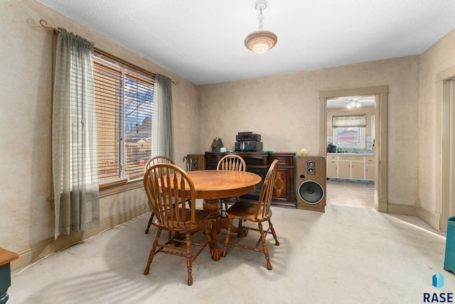 dining area featuring ceiling fan and light colored carpet