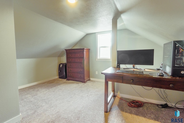 carpeted office featuring lofted ceiling and a textured ceiling