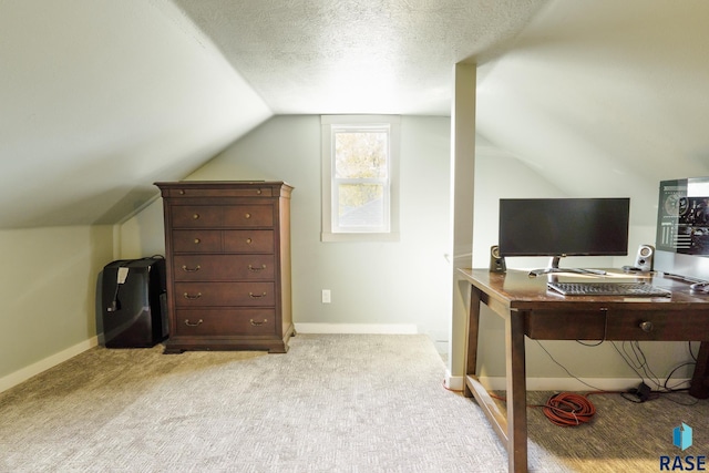 home office with light colored carpet, lofted ceiling, and a textured ceiling