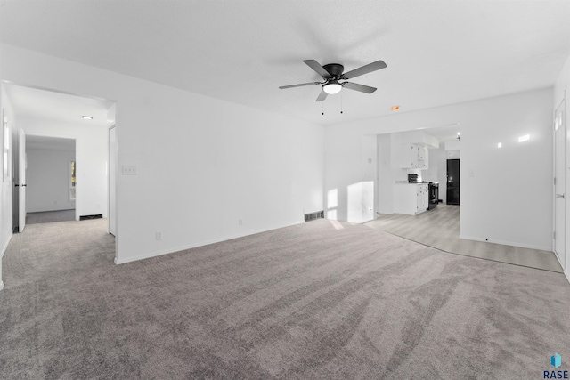 unfurnished living room featuring ceiling fan and light carpet