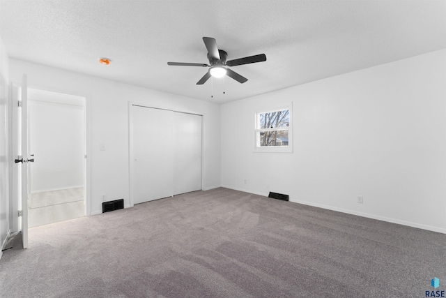 unfurnished bedroom featuring ceiling fan, carpet floors, and a textured ceiling