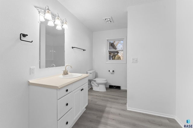 bathroom with hardwood / wood-style floors, vanity, and toilet