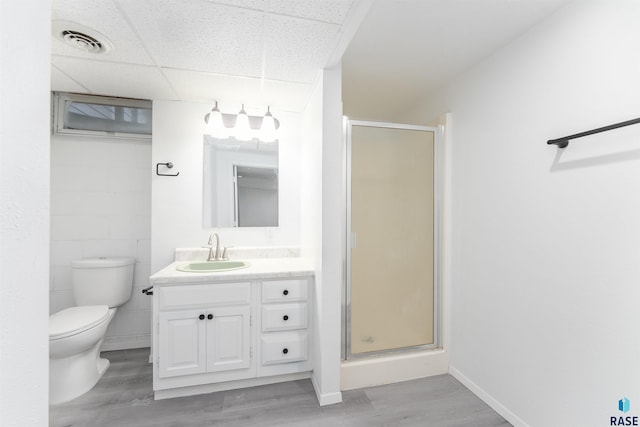 bathroom with a paneled ceiling, a shower with door, vanity, and wood-type flooring