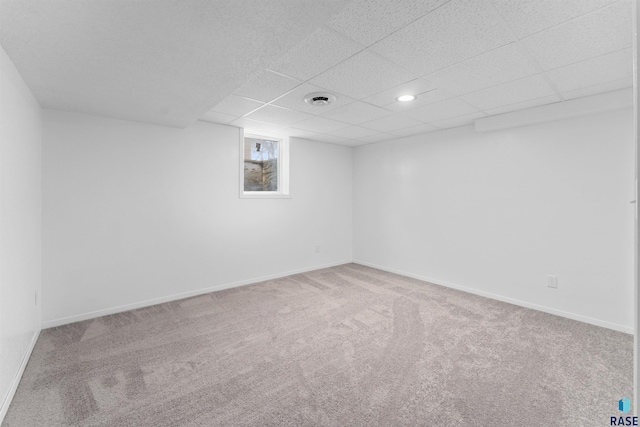 basement featuring carpet floors and a paneled ceiling