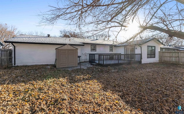 back of house with a wooden deck and a shed