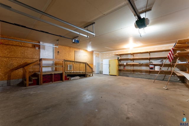 garage with a garage door opener and white refrigerator