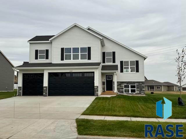 view of front of property with a front lawn and a garage