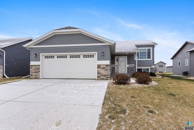 view of front facade featuring a front yard, a garage, and central air condition unit