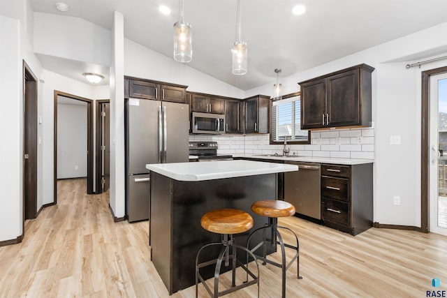 kitchen featuring a center island, a healthy amount of sunlight, stainless steel appliances, and vaulted ceiling