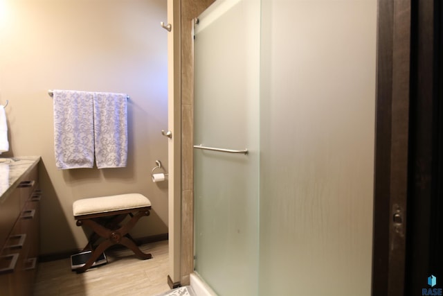 bathroom with vanity, wood-type flooring, and walk in shower