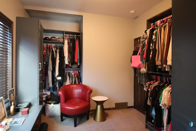 walk in closet with visible vents and light colored carpet