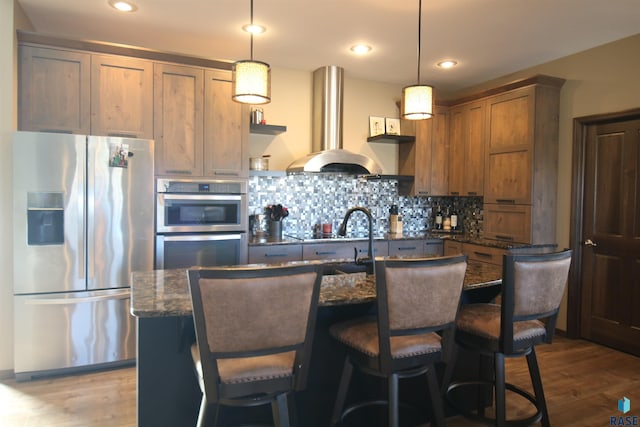 kitchen with island exhaust hood, pendant lighting, stainless steel refrigerator with ice dispenser, and wood-type flooring