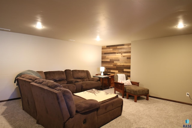 living area featuring wood walls, carpet, an accent wall, and baseboards