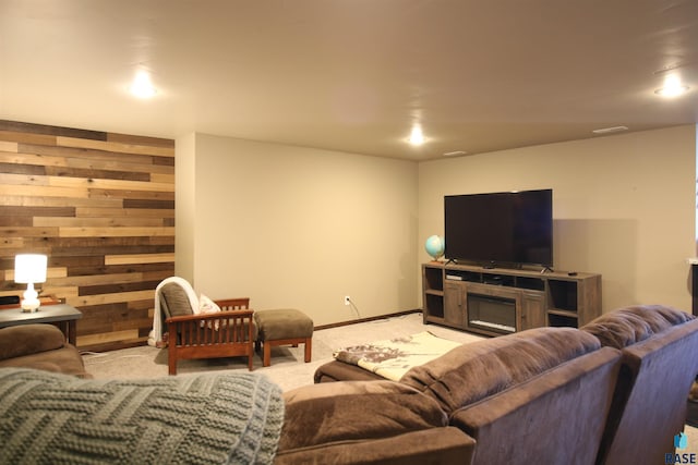 carpeted living room featuring a fireplace and wood walls