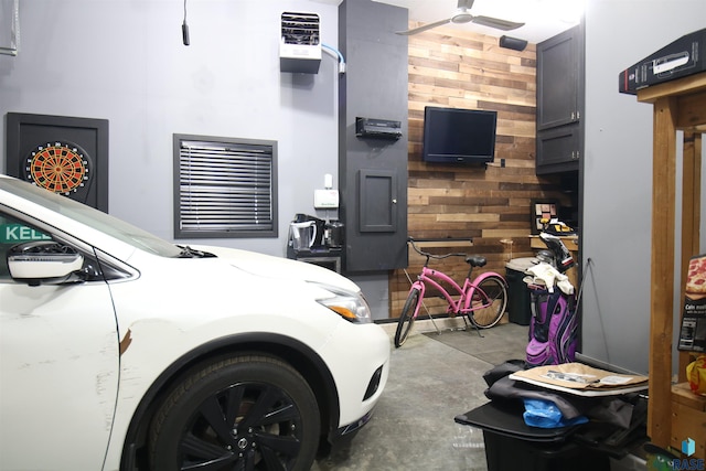 bedroom featuring a garage, concrete floors, and wood walls