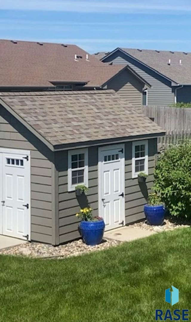 view of outdoor structure featuring an outbuilding and fence