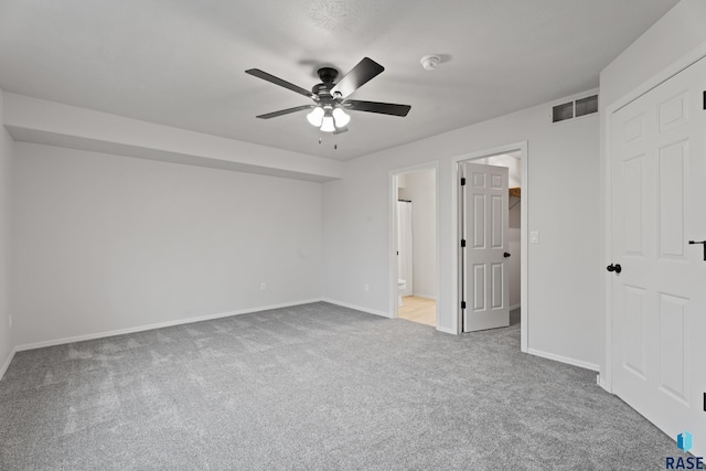 unfurnished bedroom with carpet flooring, ensuite bathroom, and ceiling fan