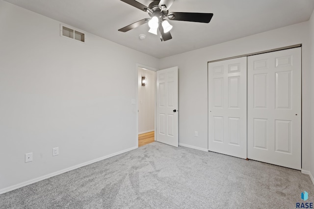 unfurnished bedroom with ceiling fan, a closet, and light colored carpet