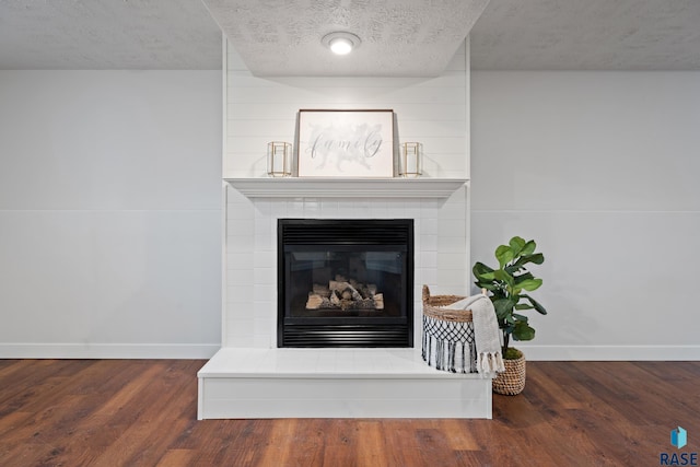 details featuring a fireplace, a textured ceiling, and hardwood / wood-style flooring