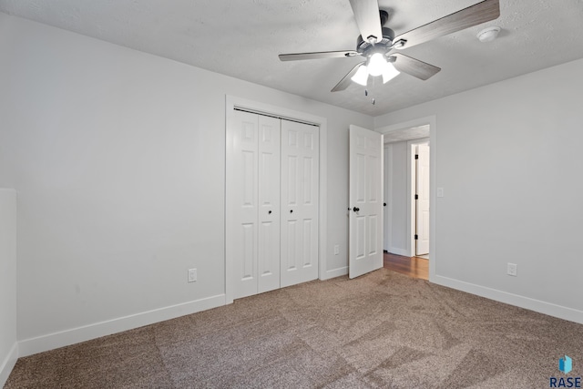 unfurnished bedroom with carpet flooring, a textured ceiling, a closet, and ceiling fan