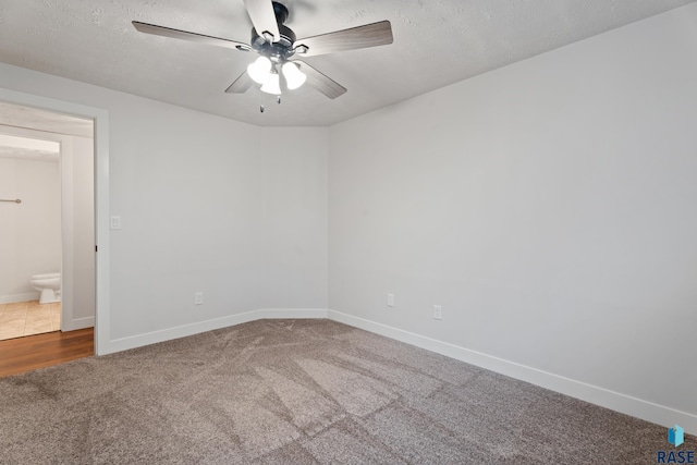 carpeted empty room featuring ceiling fan and a textured ceiling