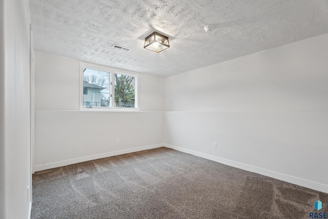 carpeted empty room with a textured ceiling