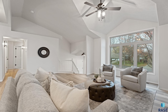 living room featuring ceiling fan, vaulted ceiling, and light wood-type flooring